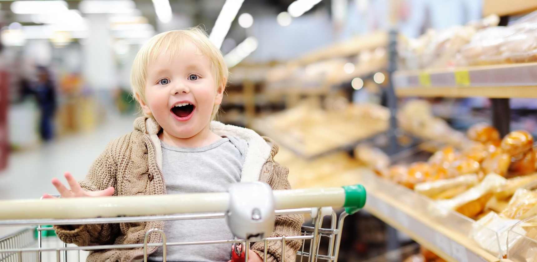 toddler smiling on shopping cart